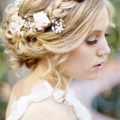 Braided crown hairstyle for wedding day with flowers and low bun 1